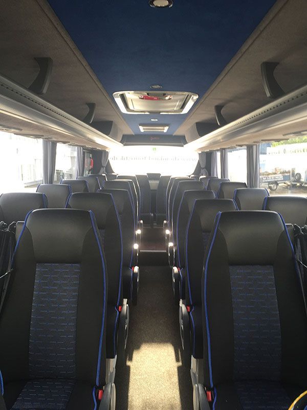 Das Innere eines Busses mit schwarzen und blauen Sitzen