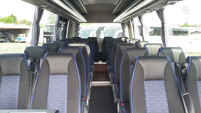 Das Innere eines Busses mit schwarzen und blauen Sitzen