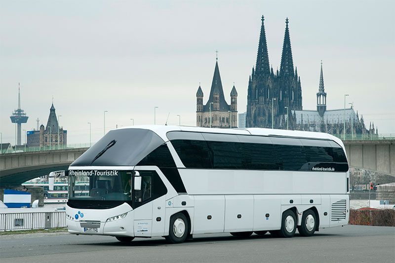 Ein großer weißer Bus steht vor einer Kathedrale