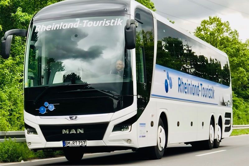Ein weißer Bus mit dem Wort Rheinland Touristik auf der Vorderseite