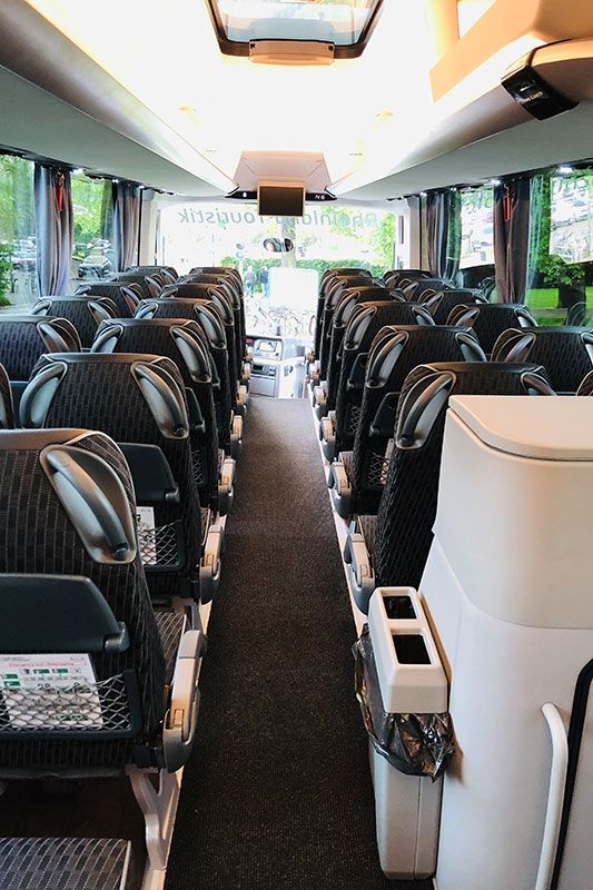 Das Innere eines Busses mit vielen Sitzen und einem Mülleimer
