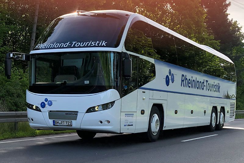 Ein weiß-blauer Bus mit dem Wort Touristik auf der Vorderseite