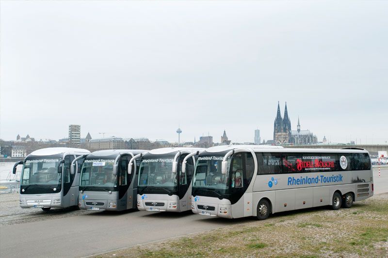 Eine Reihe von Bussen parkt vor einer Stadt