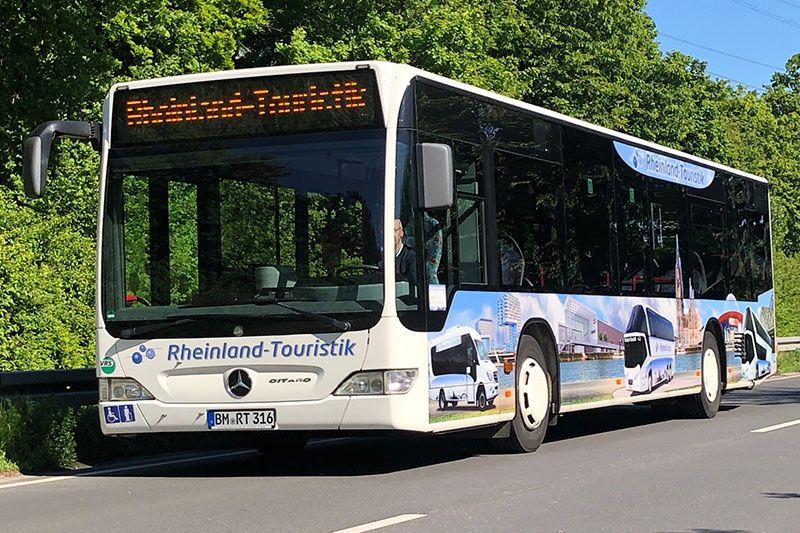Ein Rheinland Touristik Bus fährt die Straße entlang