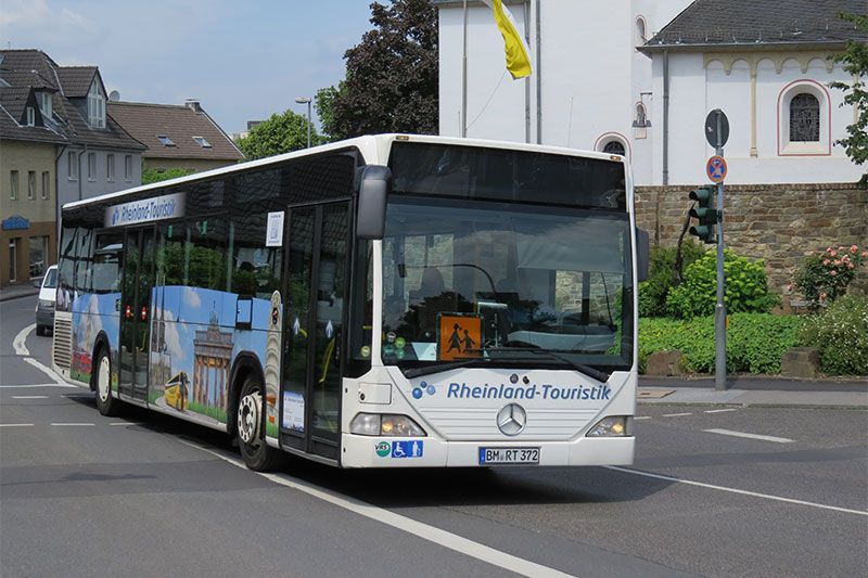 Ein Mercedes-Bus fährt eine Straße entlang