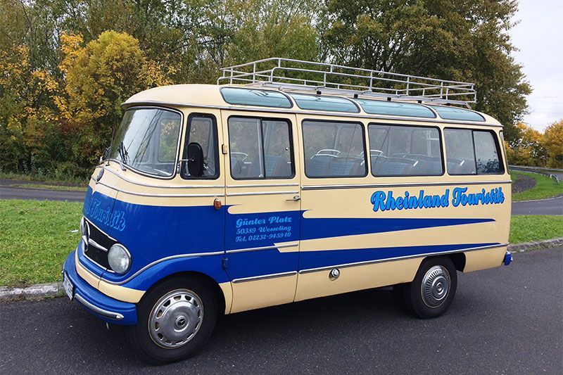 Ein blau-weißer Bus mit dem Wort Rheinland Tourismus auf der Seite