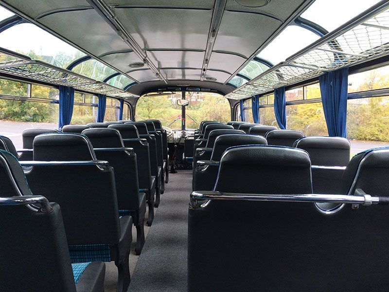 Das Innere eines Busses mit blauen Vorhängen und schwarzen Sitzen