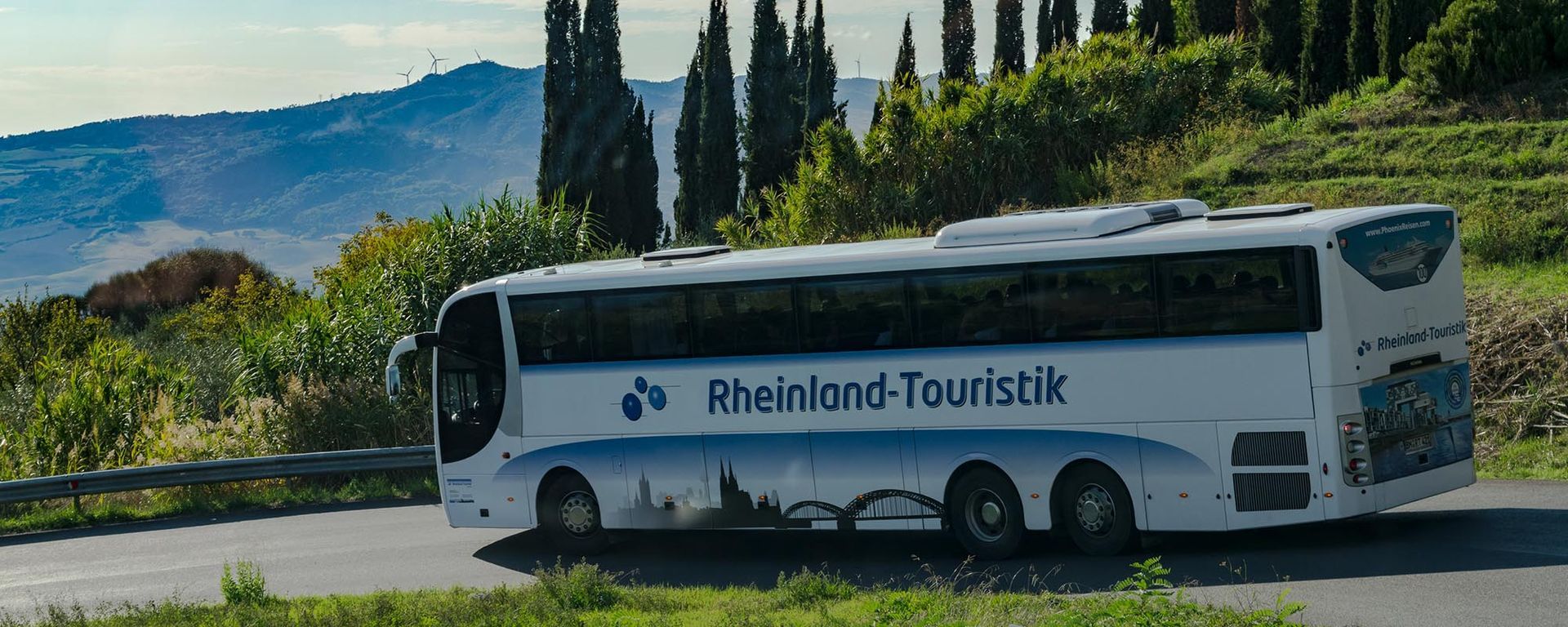 Ein Bus der Rheinland-Touristik fährt eine Straße entlang
