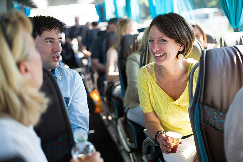 Eine Gruppe von Leuten sitzt in einem Bus und unterhält sich