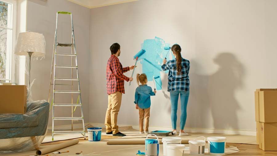 Famille qui peint un mur en bleu