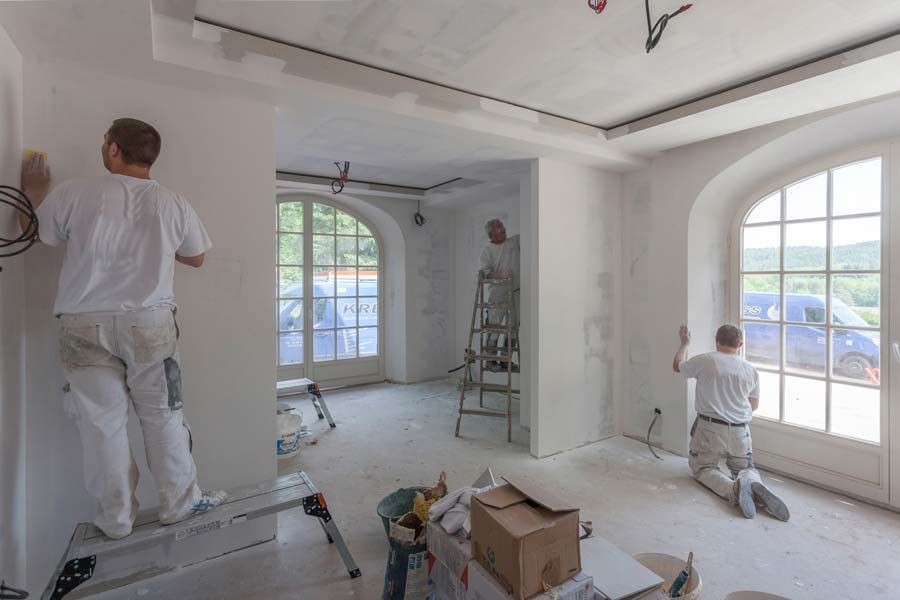 Trois peintres en train de re peindre une salle dans une maison