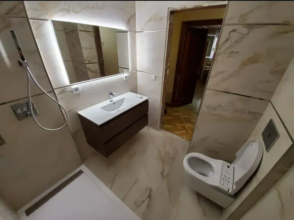 Un baño con inodoro, lavabo y espejo.