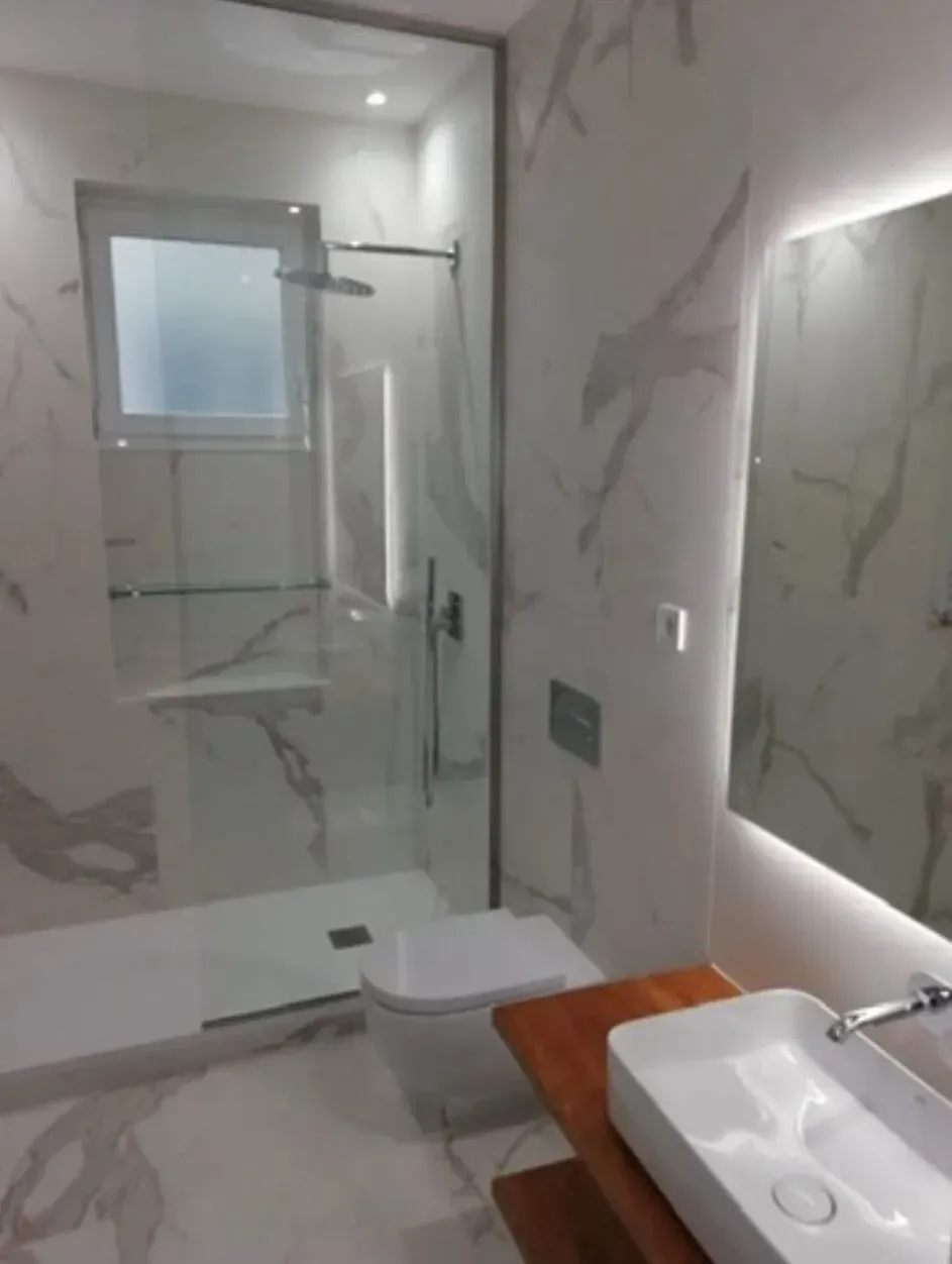 Un baño con lavabo, inodoro, ducha y espejo.