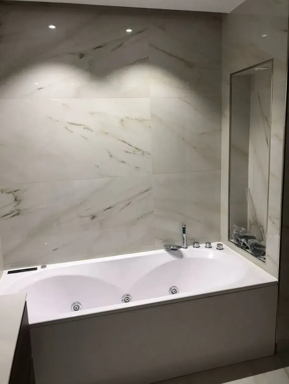 Un baño con bañera y espejo.