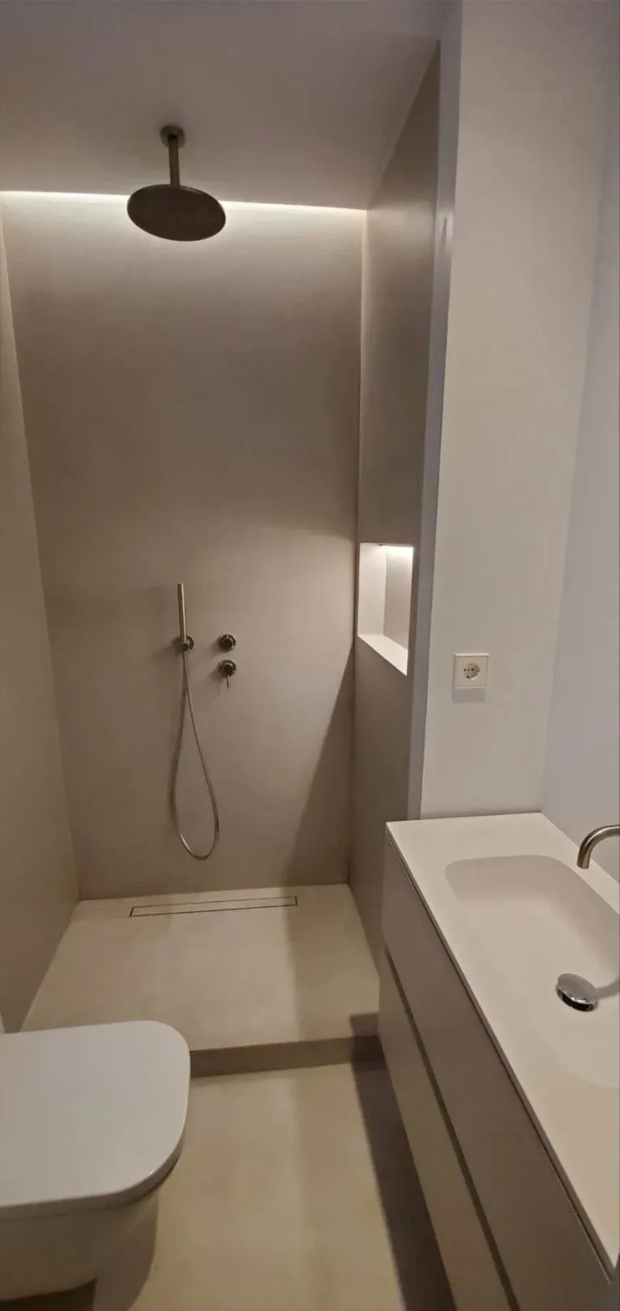 Un baño con inodoro, lavabo y ducha.