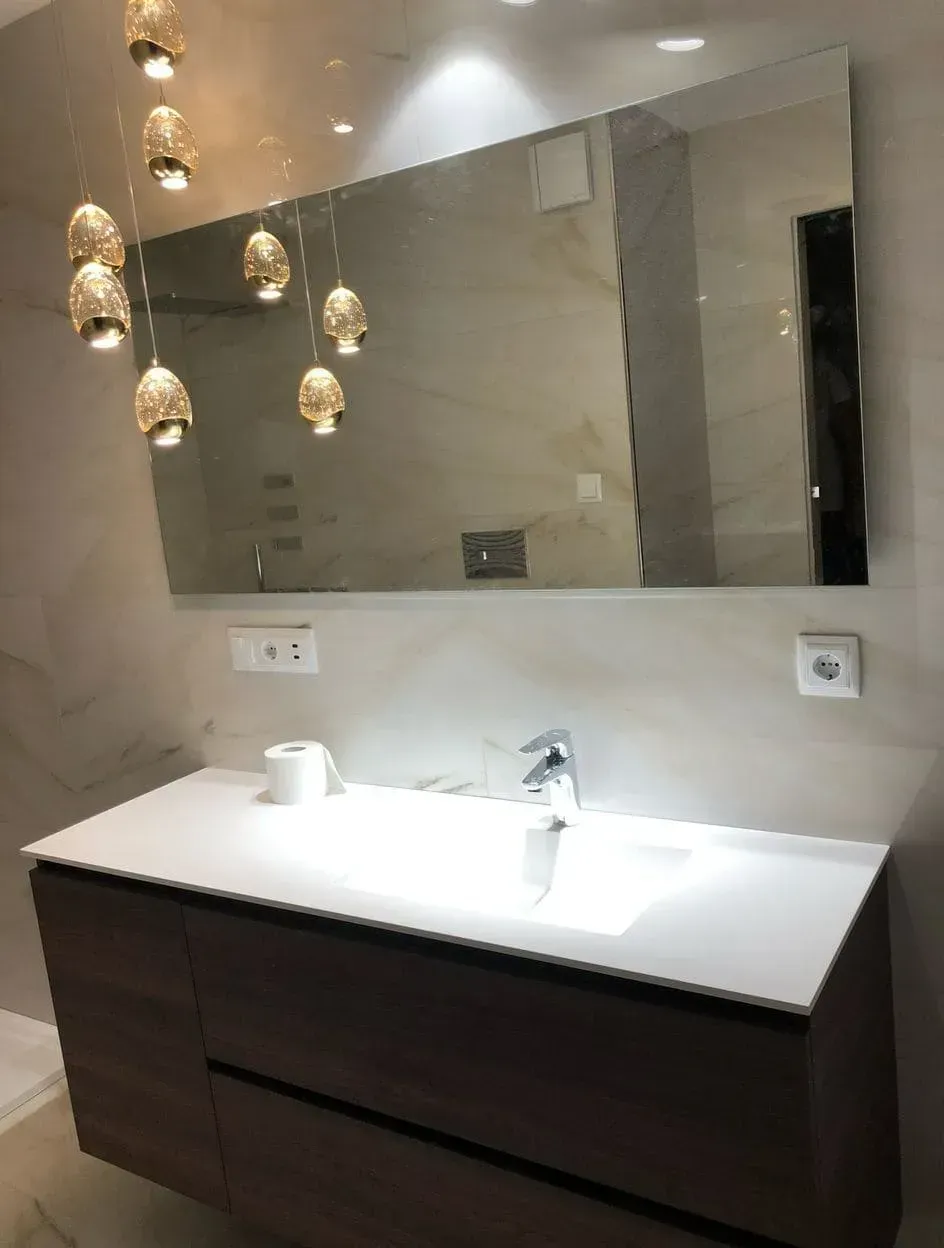 Un baño con un gran espejo y un lavabo.