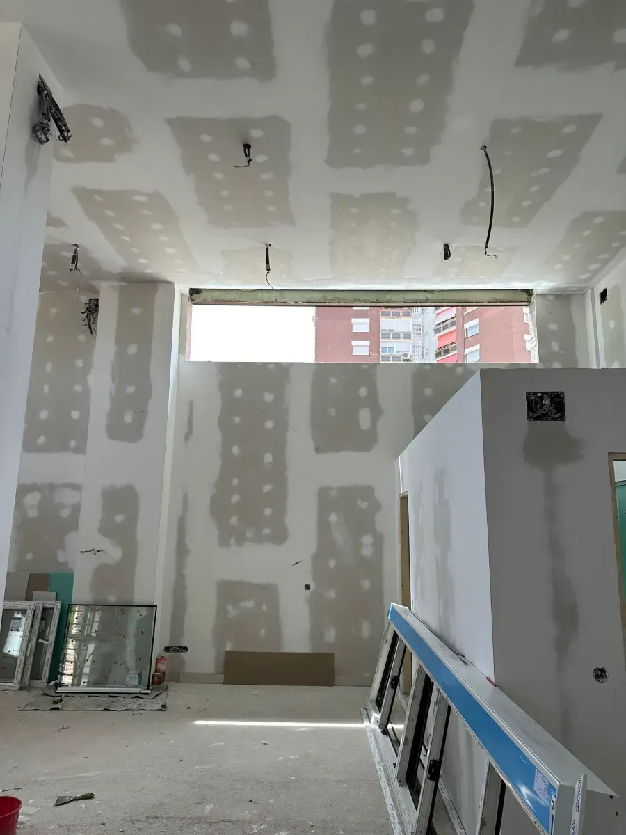 Una habitación con una ventana y una escalera en ella.