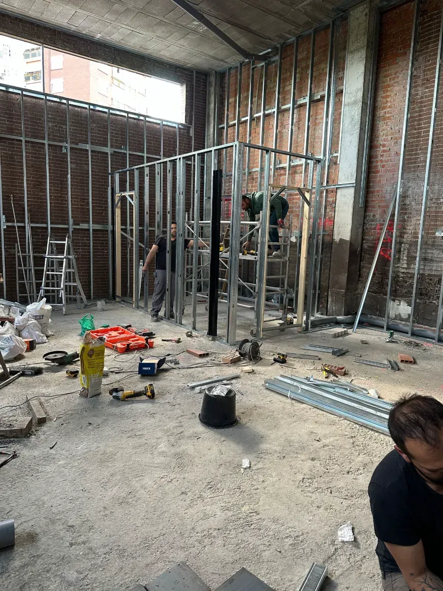 Un hombre está sentado en el suelo de un edificio en construcción.