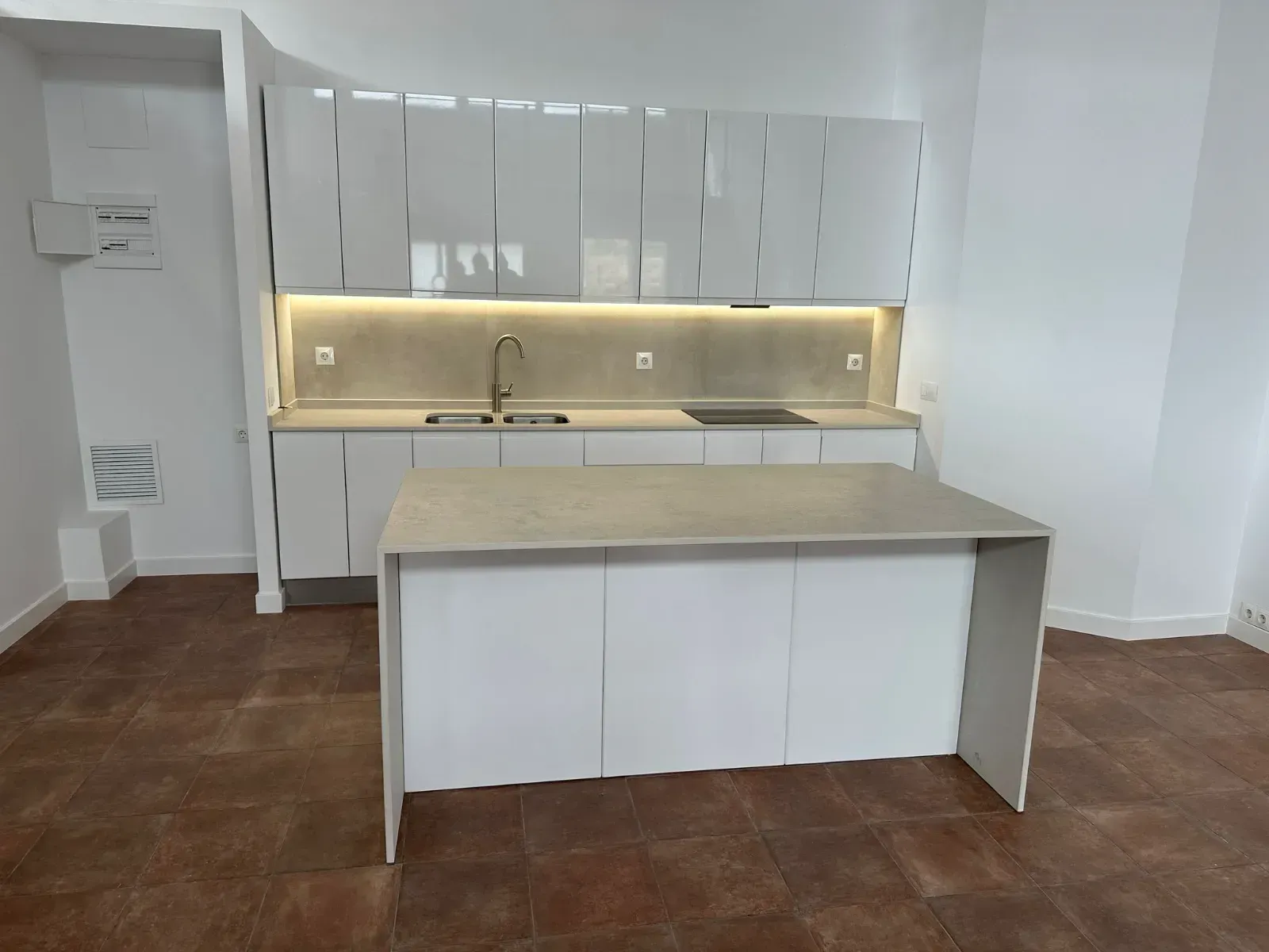 Una cocina con gabinetes blancos y una gran isla en el medio.