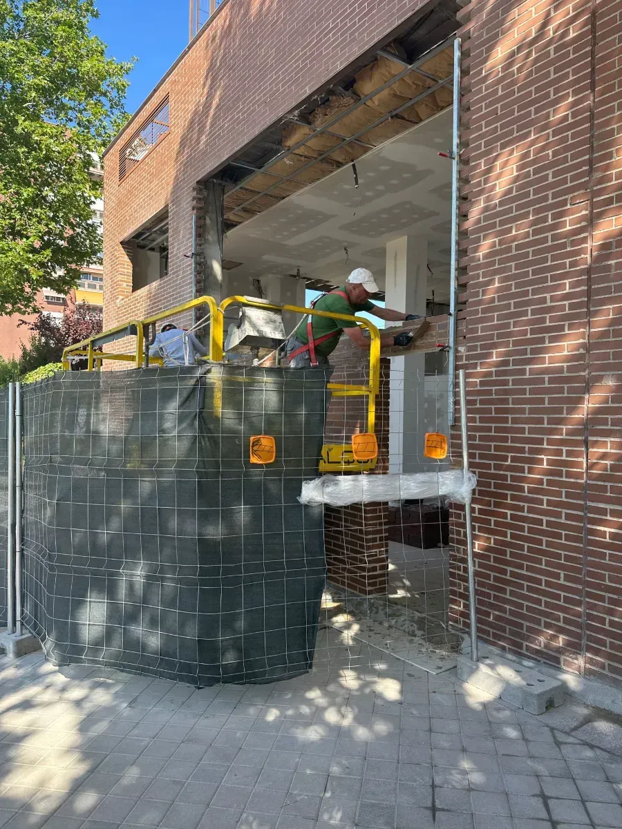Un hombre está parado en un ascensor frente a un edificio de ladrillos.
