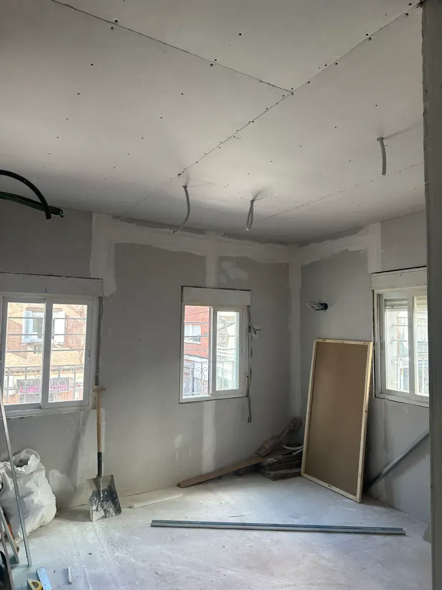 Una habitación con muchas ventanas y una pala dentro.