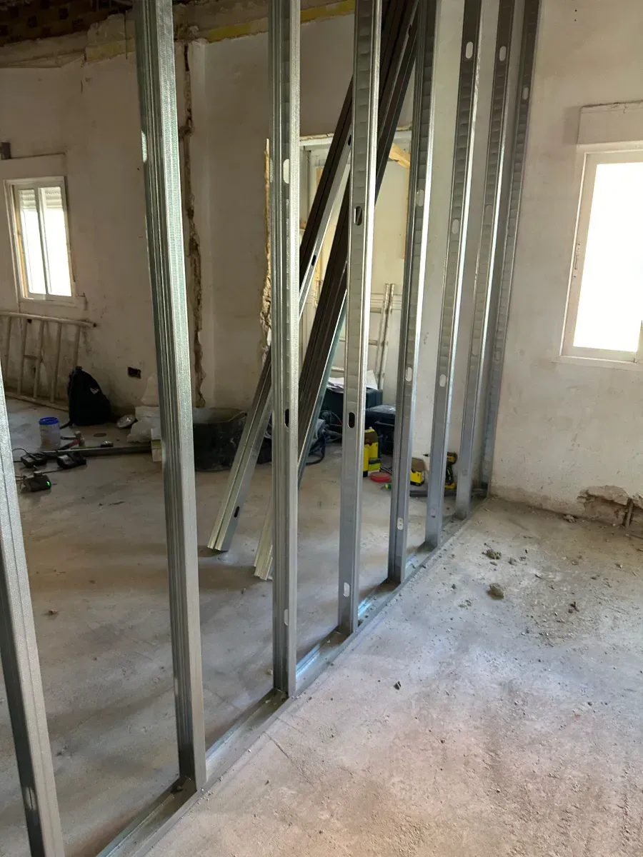 Una habitación con muchos marcos de metal en la pared.