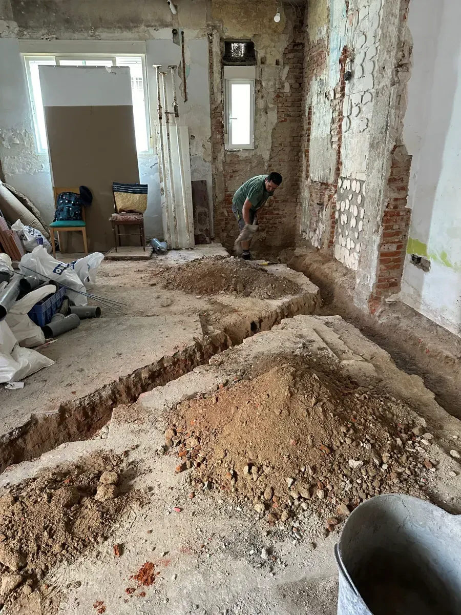 Un hombre está cavando un hoyo en el suelo de una habitación.
