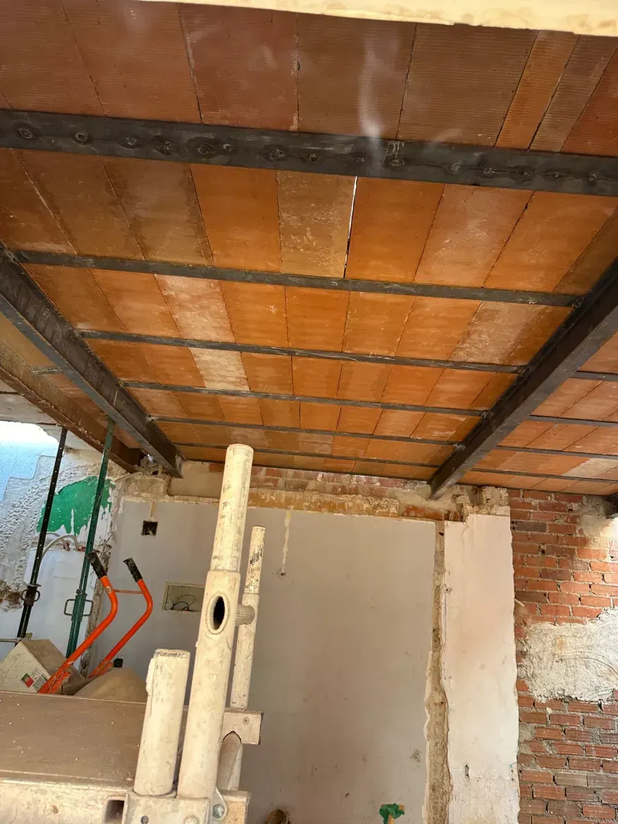 Un techo de ladrillo con estructura de metal en una habitación.