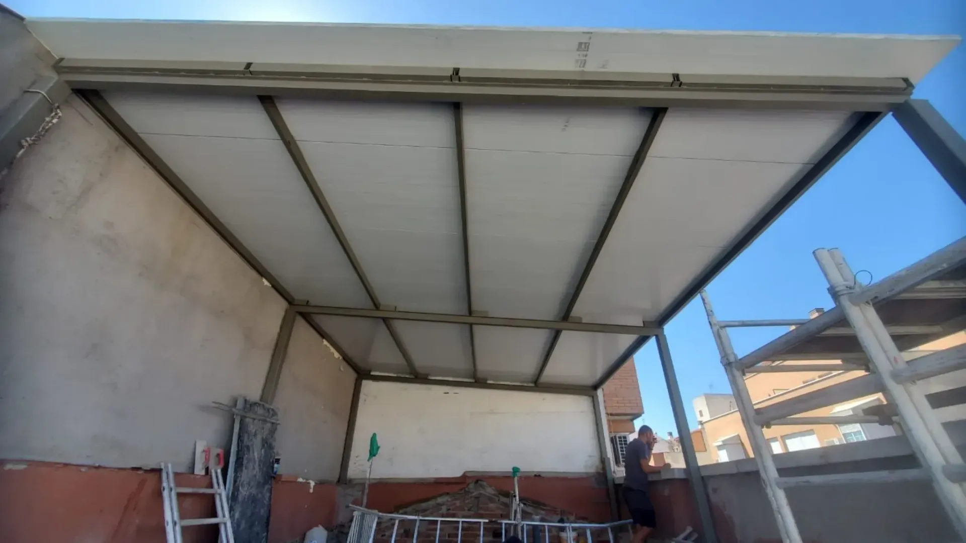 Un hombre está trabajando en el tejado de un edificio.