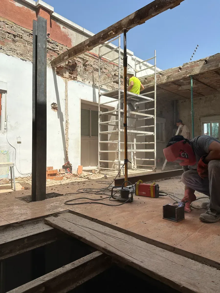 Un hombre que lleva una máscara de soldador está trabajando en un piso de madera.