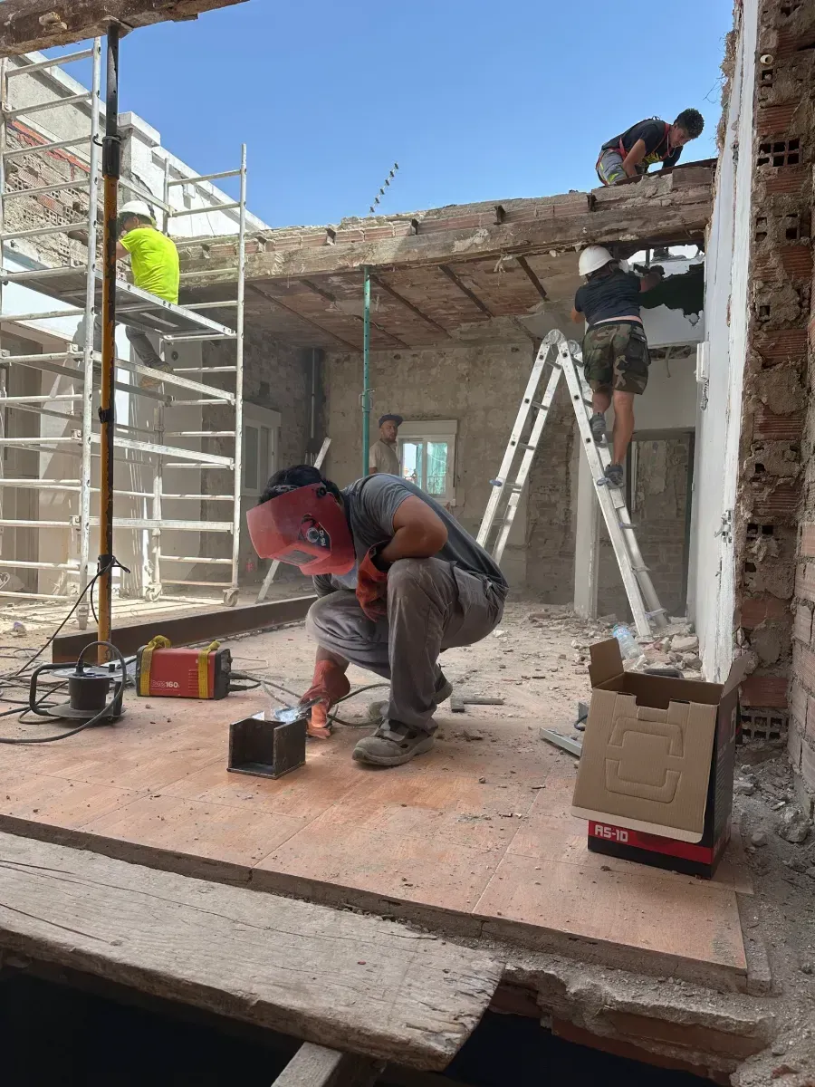 Un hombre está trabajando en un piso de madera en un edificio en construcción.