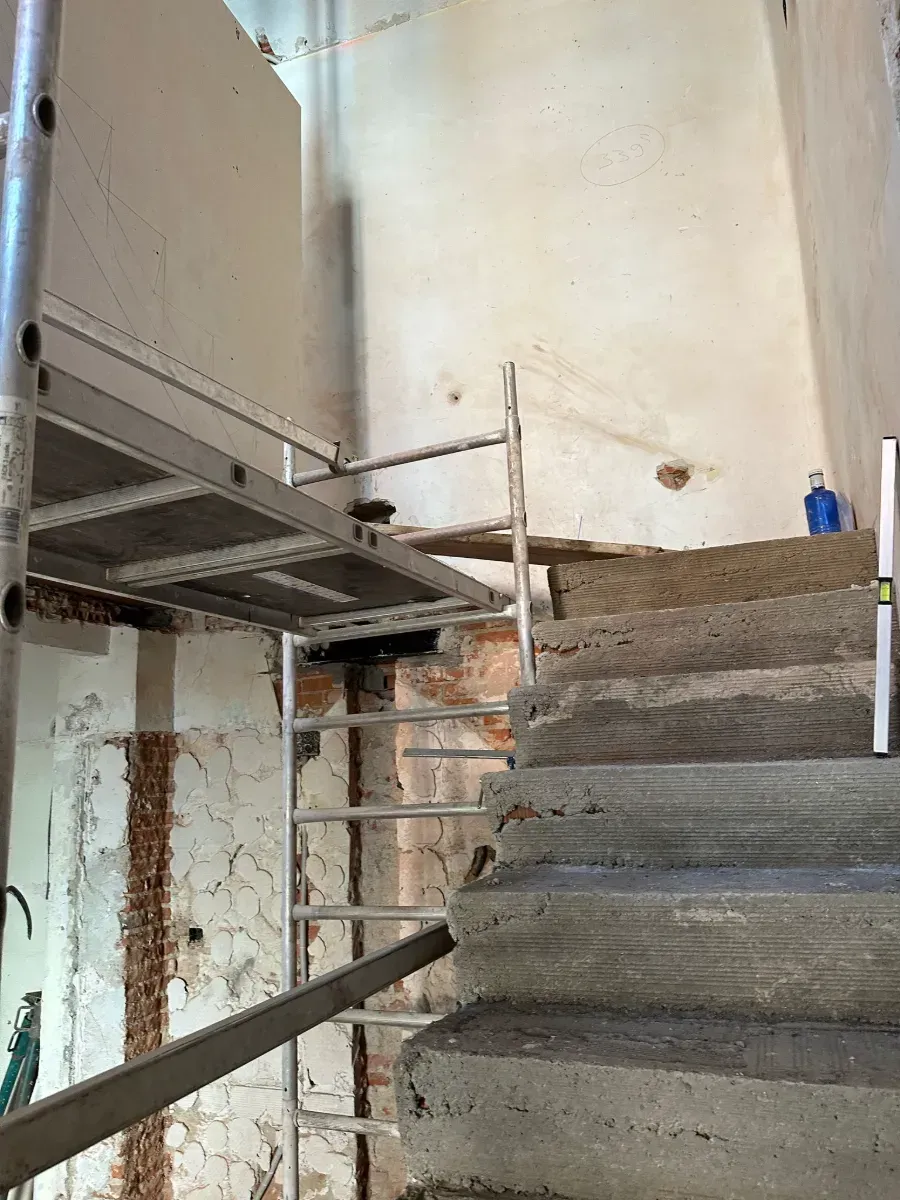 Una escalera está colocada encima de una escalera de hormigón.