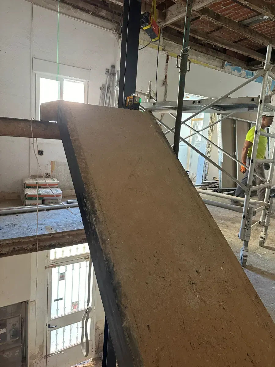 Un hombre está de pie en una escalera en un edificio en construcción.