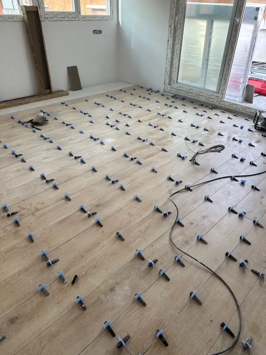 Una habitación con suelo de madera y una aspiradora encima.