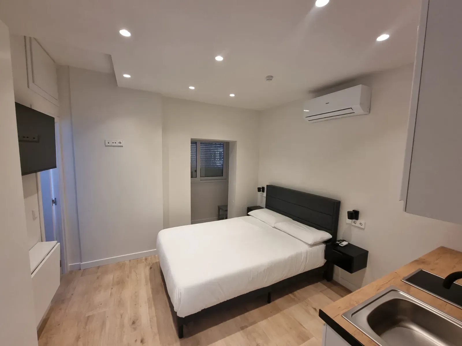 Un dormitorio con una cama king size y un lavabo.