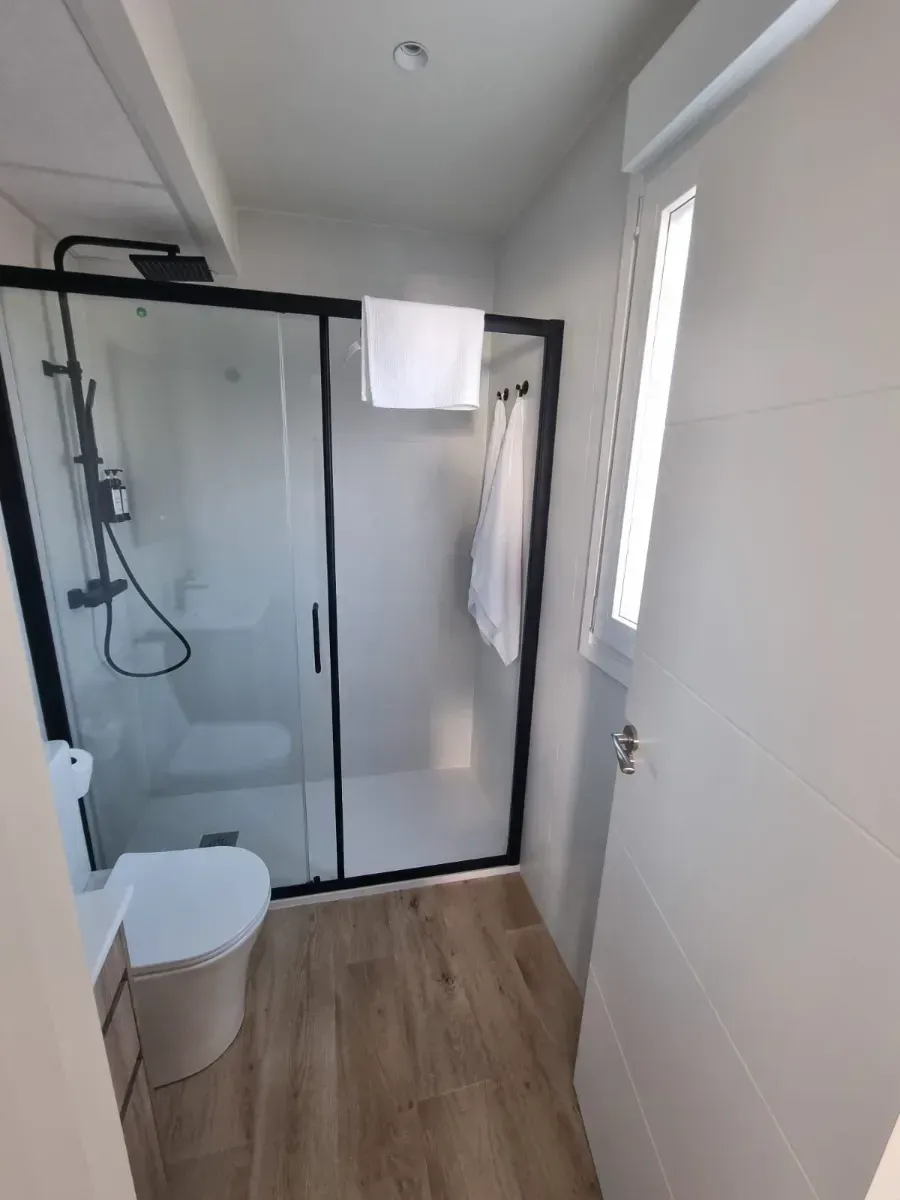 Un baño con inodoro, ducha y ventana.