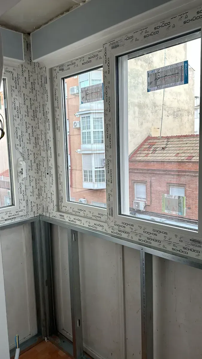 Una habitación con una ventana y vista a un edificio.