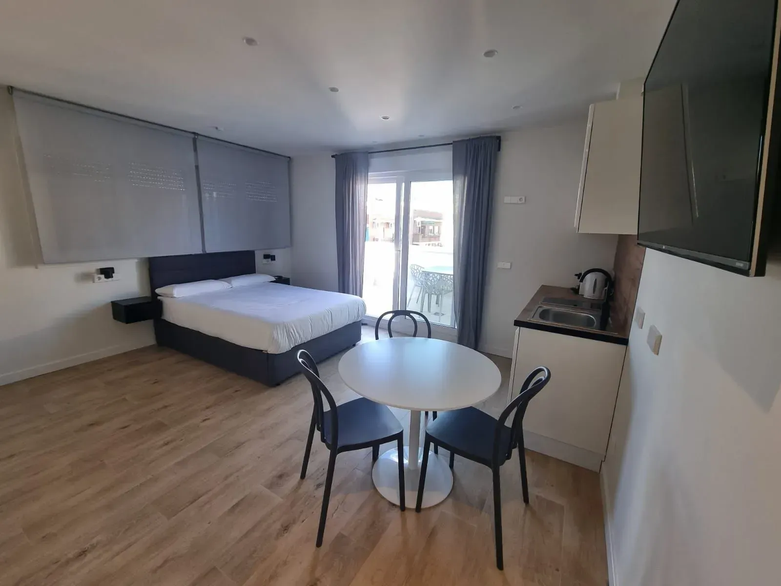 Una habitación de hotel con una cama, mesa y sillas.