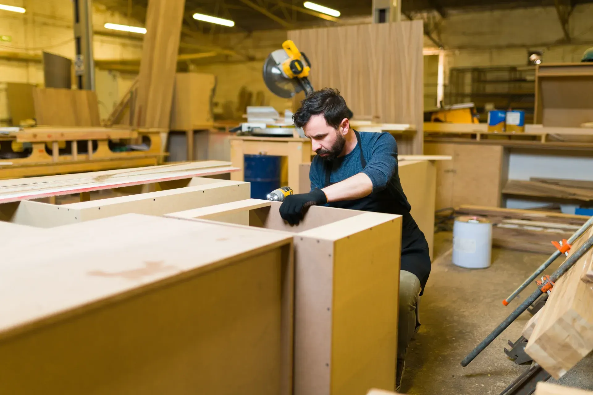 Un hombre está trabajando en un trozo de madera en un taller de carpintería.