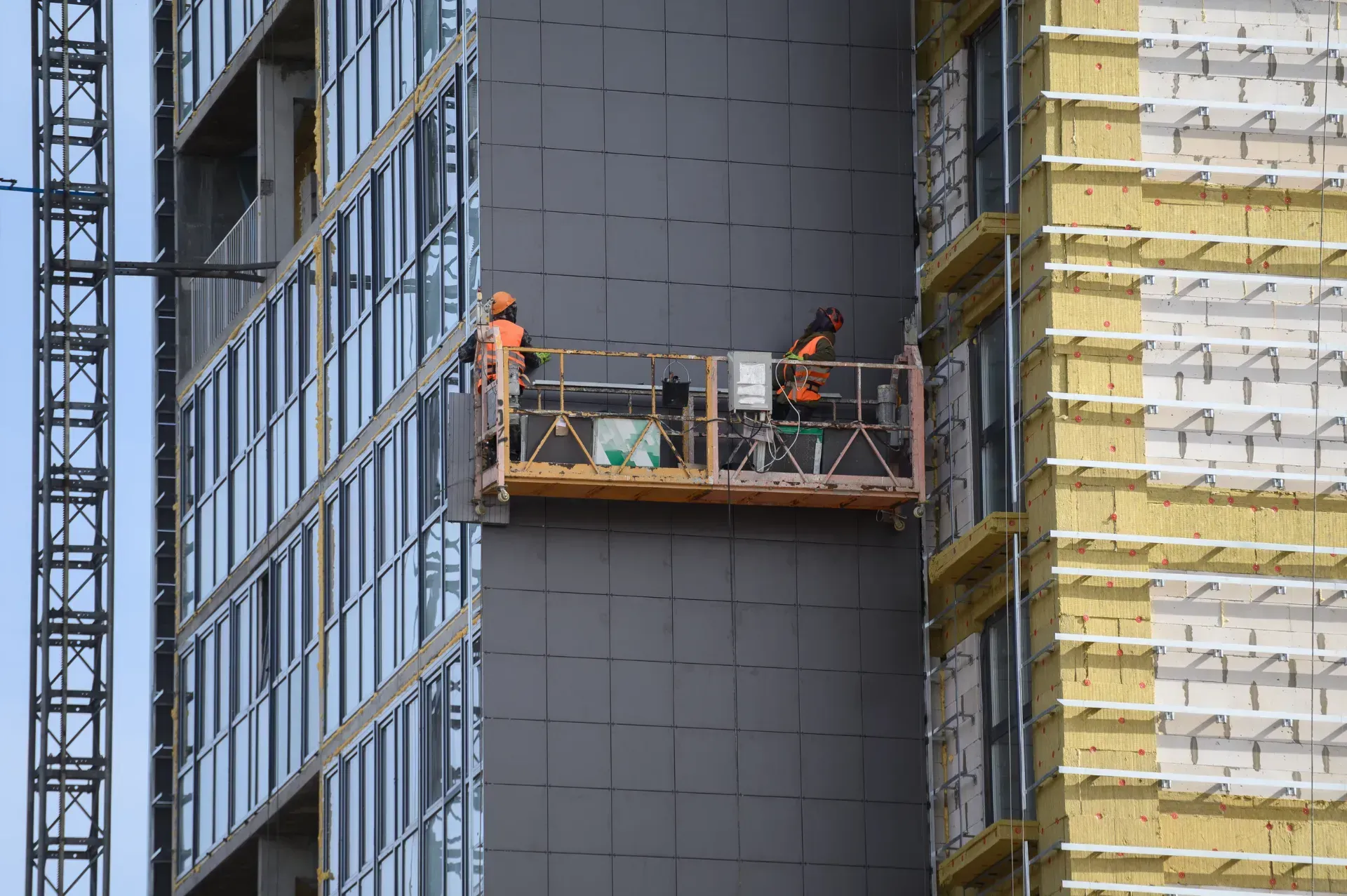 Un grupo de trabajadores de la construcción está trabajando en el lateral de un edificio.