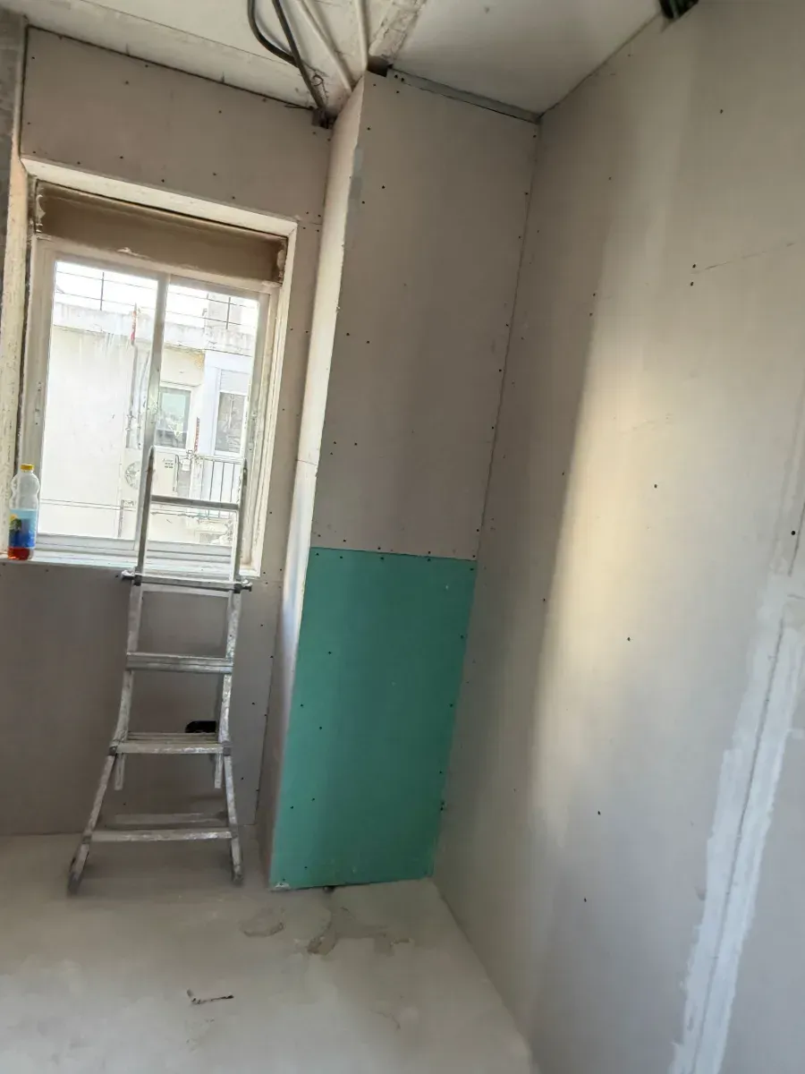 Una habitación con una escalera y una ventana.