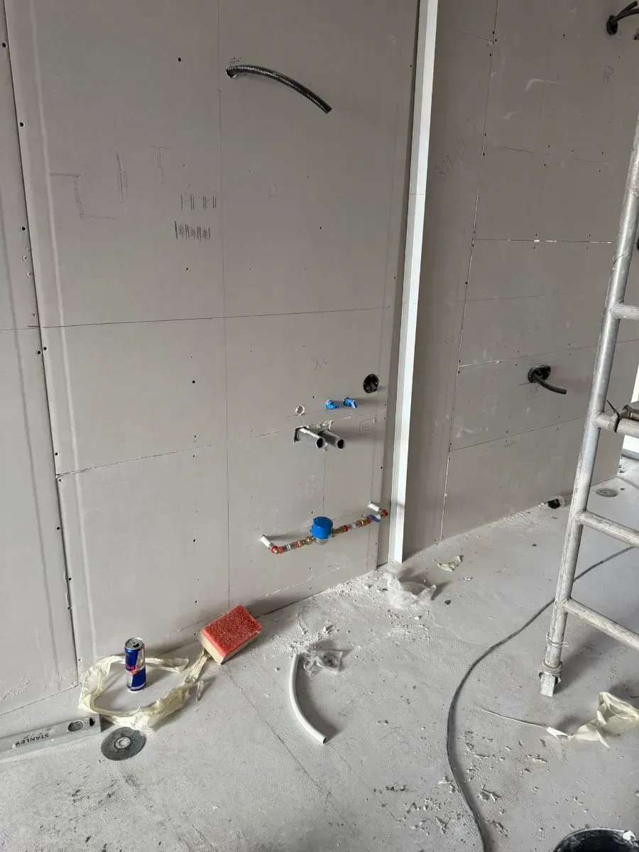 Una escalera está apoyada en el suelo en una habitación en construcción.