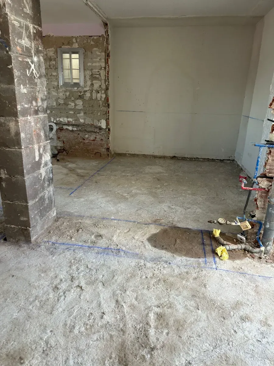 Una habitación que está siendo remodelada con mucha suciedad en el piso.