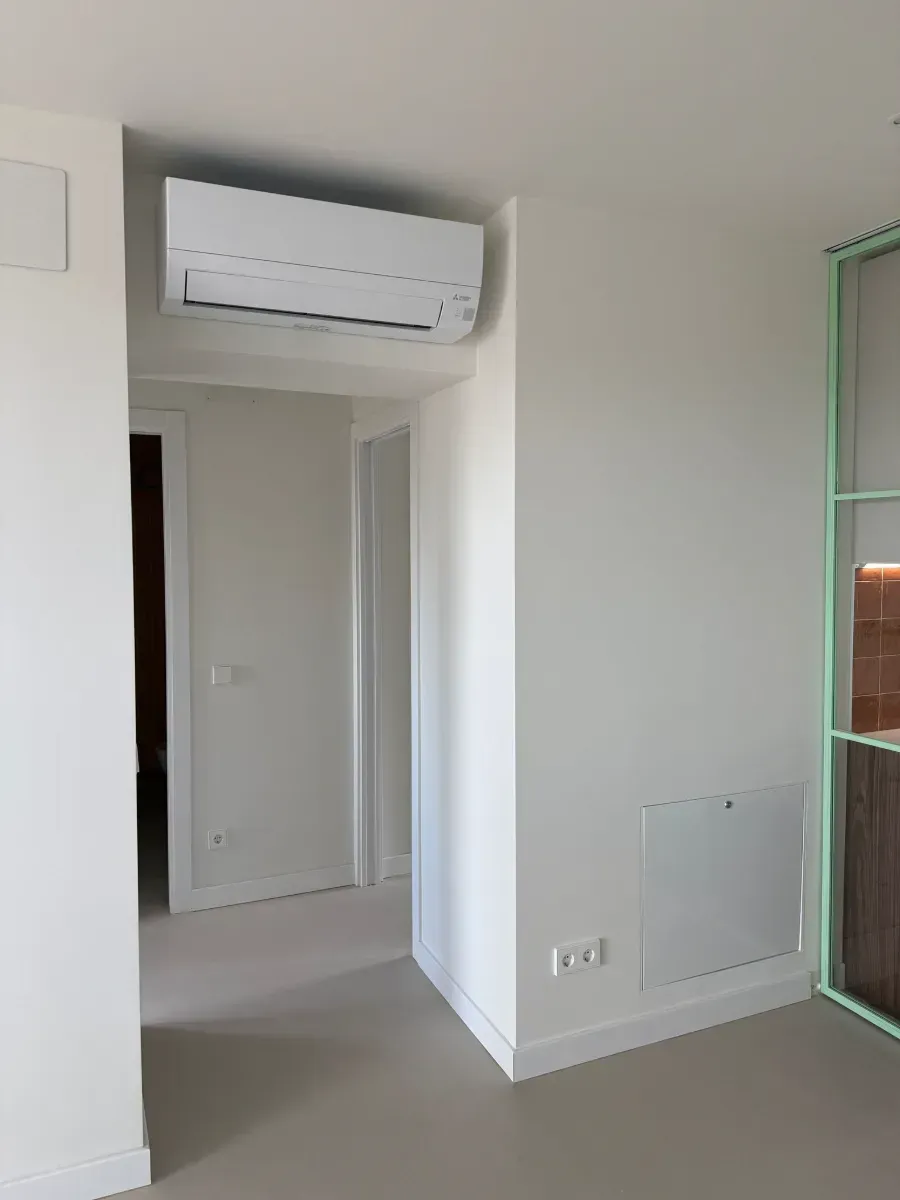 Una habitación vacía con paredes blancas y una puerta verde.
