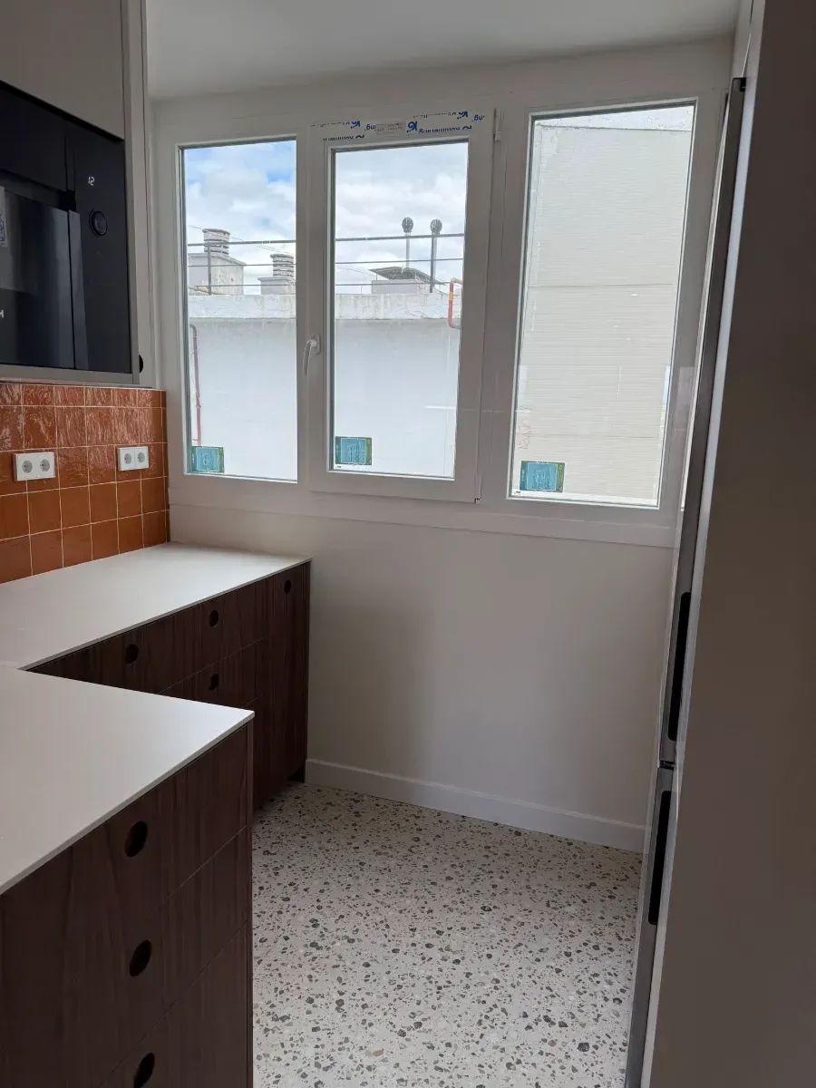 Una cocina con muchas ventanas y armarios.