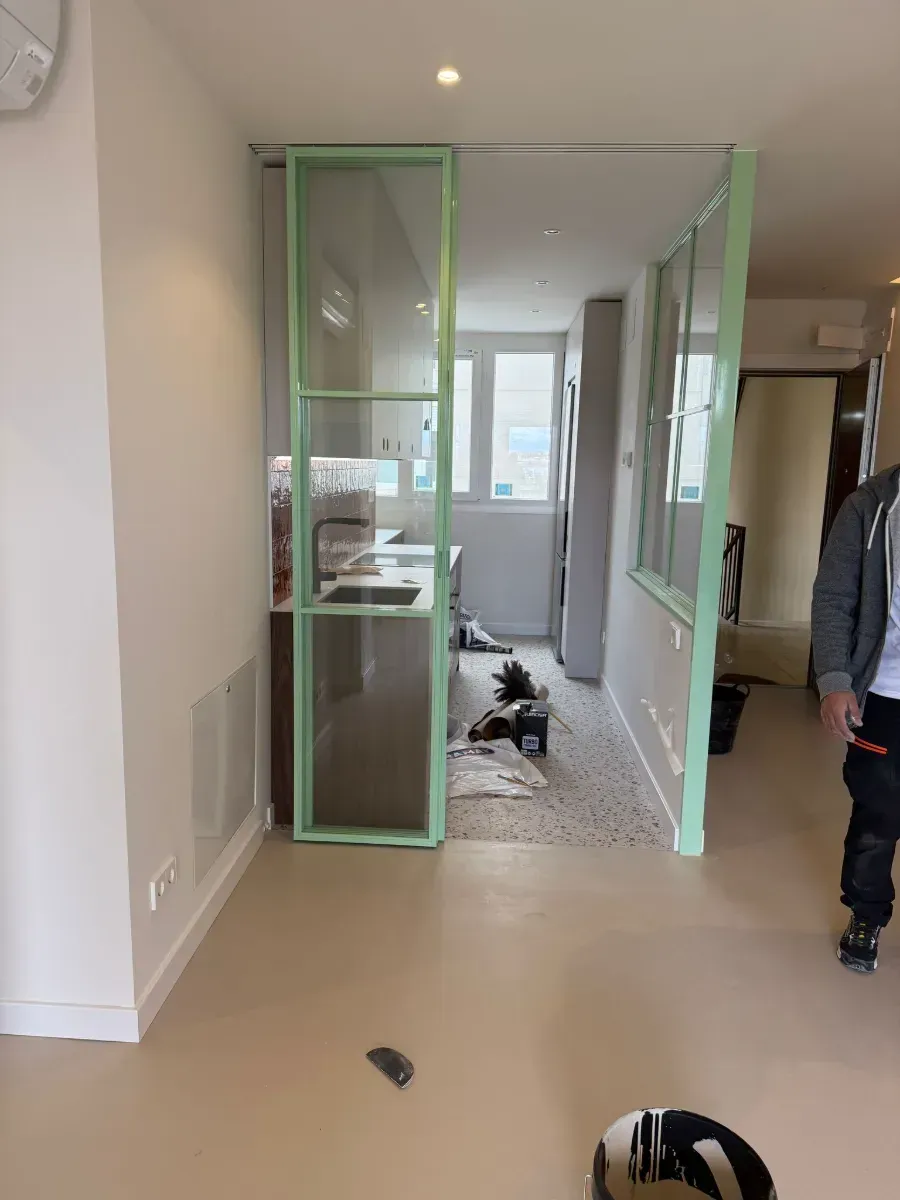 Un hombre está de pie en una habitación con un reloj en la pared.