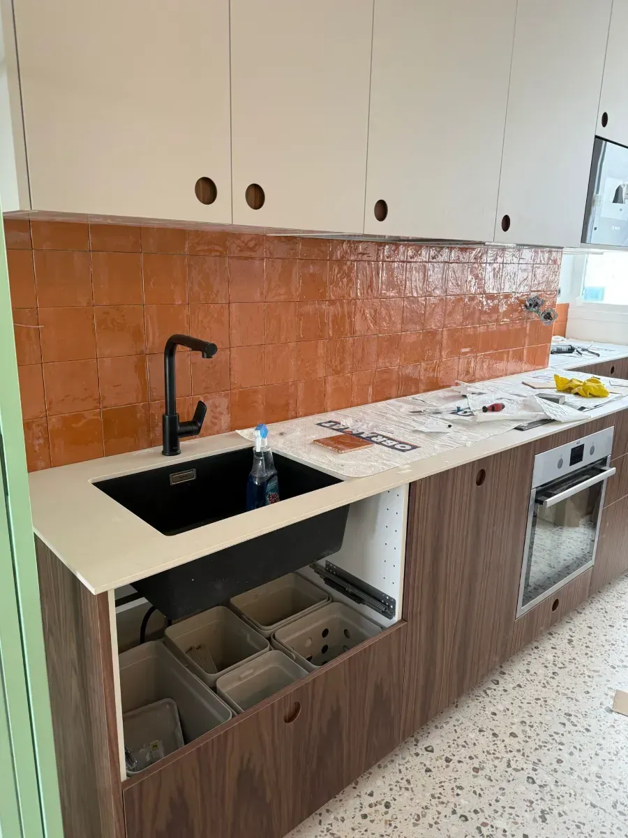 Una cocina con fregadero, estufa y horno.