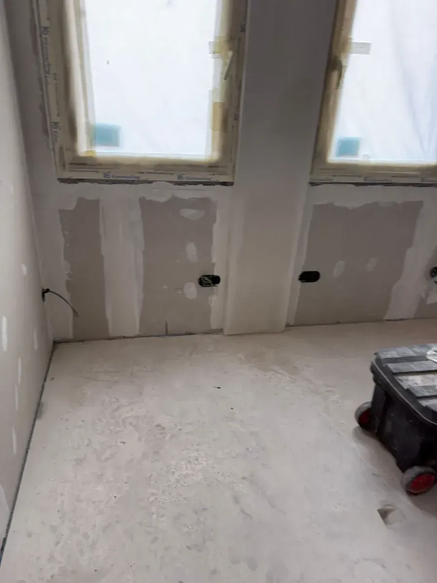 Una habitación con una caja en el suelo y una ventana.