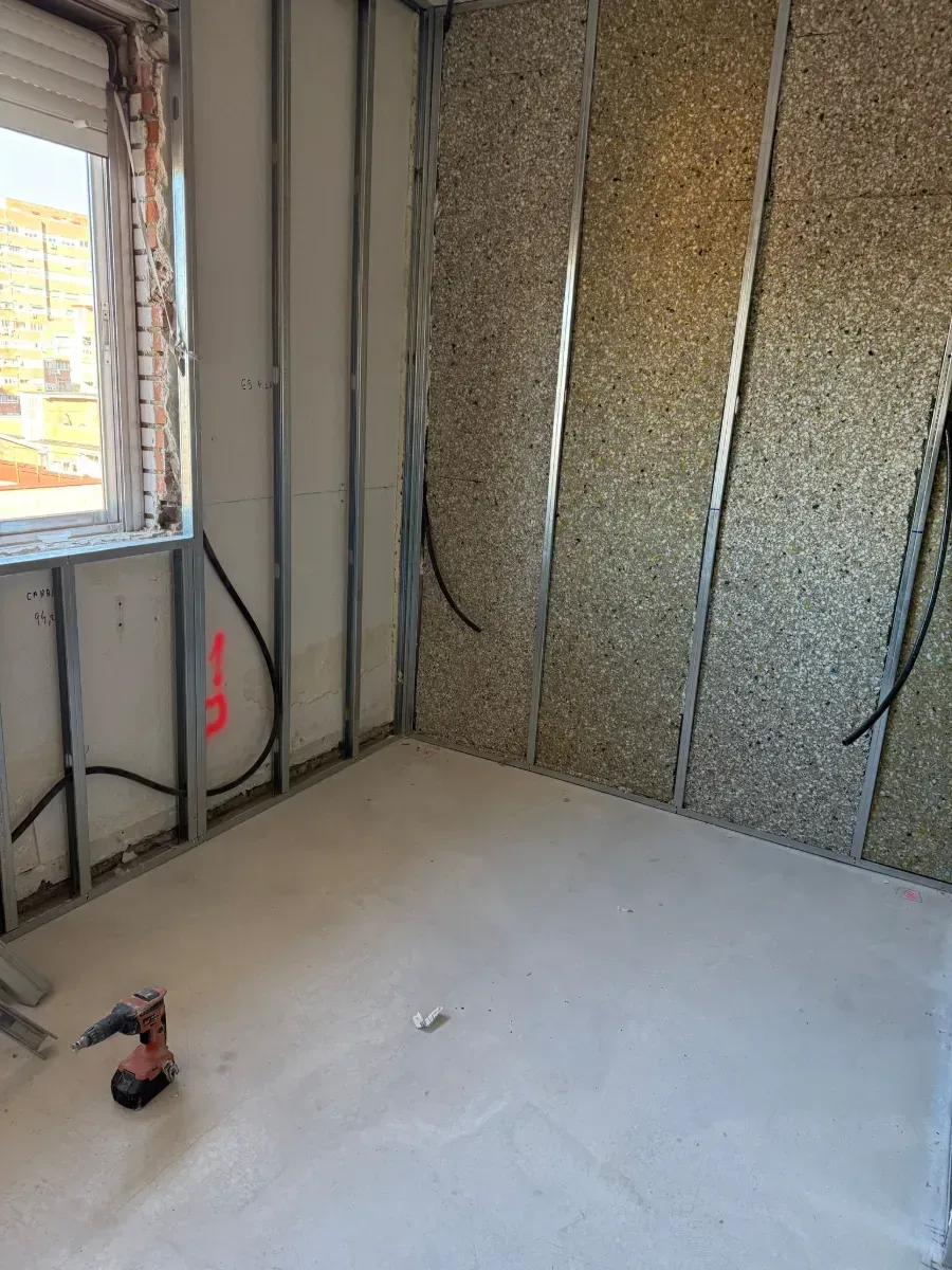 Una habitación con un taladro en el suelo y una ventana.