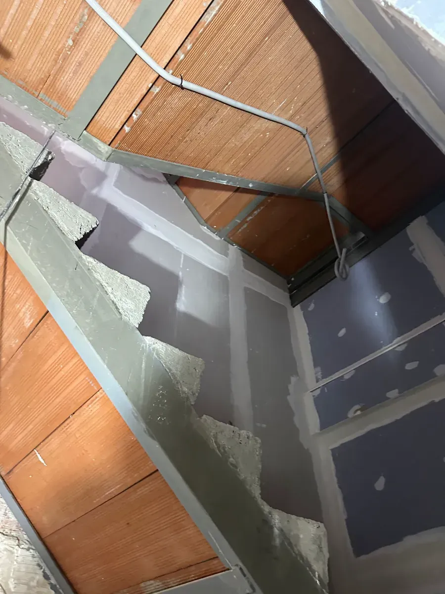 Se está construyendo una escalera en una habitación con techo de madera.